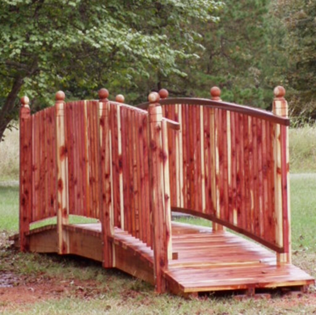 12-foot handcrafted cedar spindle rail bridge with decorative posts, built for gardens and outdoor landscape