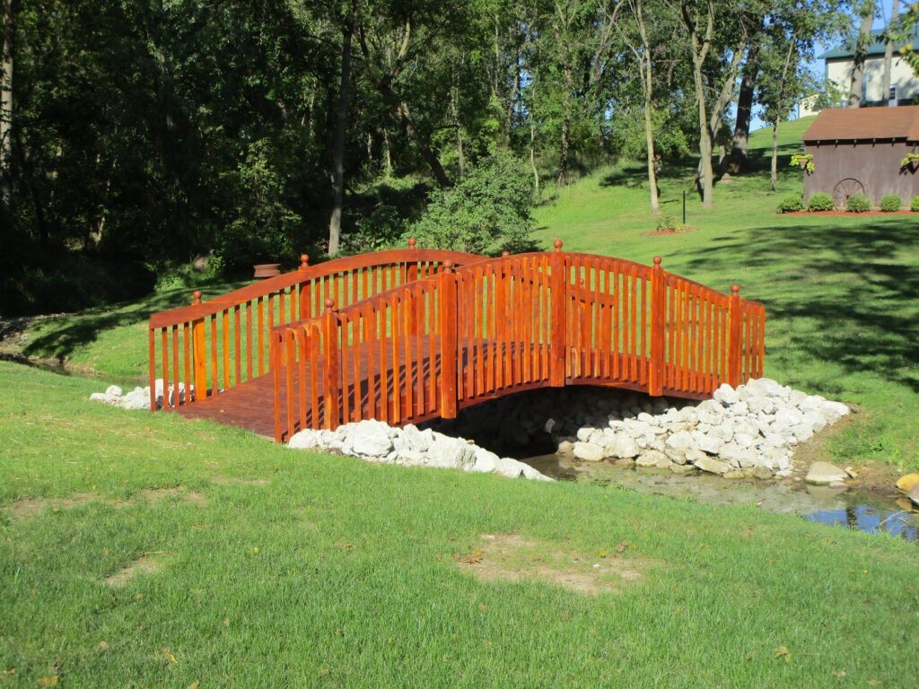 20-foot red cedar spindle rail garden bridge featuring tall spindles and smooth curved handrails