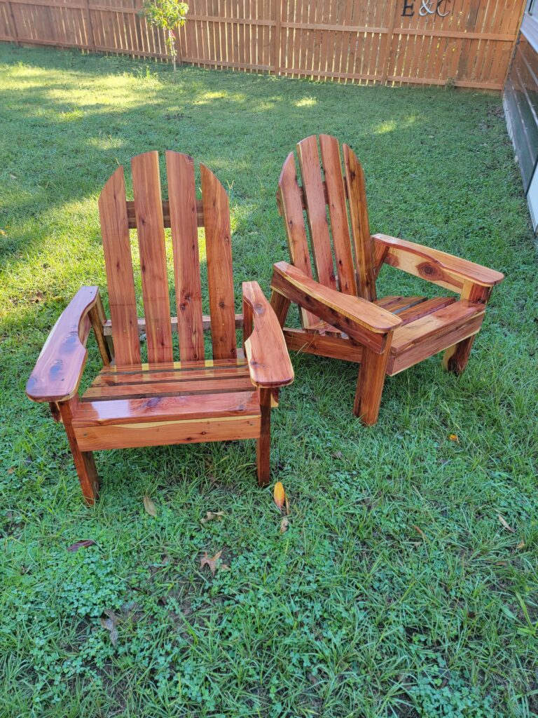 Pair of handcrafted cedar Adirondack chairs made from Eastern Red Cedar, ideal for patios, porches, and gardens.