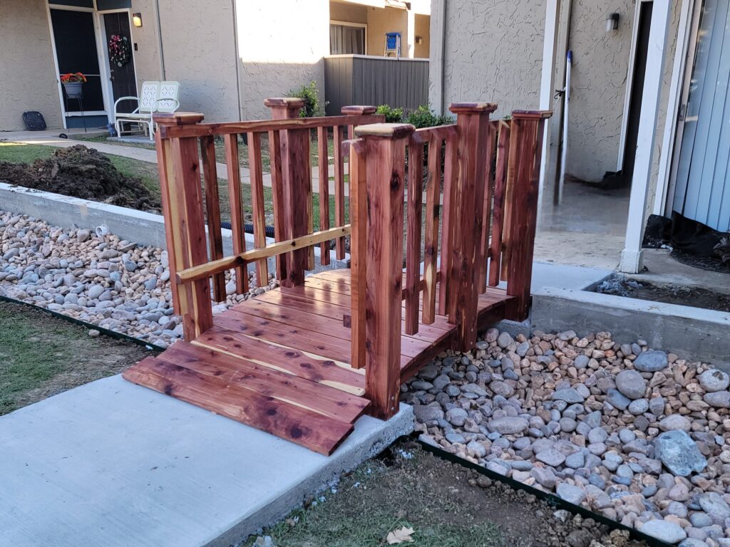 6-foot handcrafted cedar spindle rail bridge installed at Holly Springs Apartments in Denton, TX