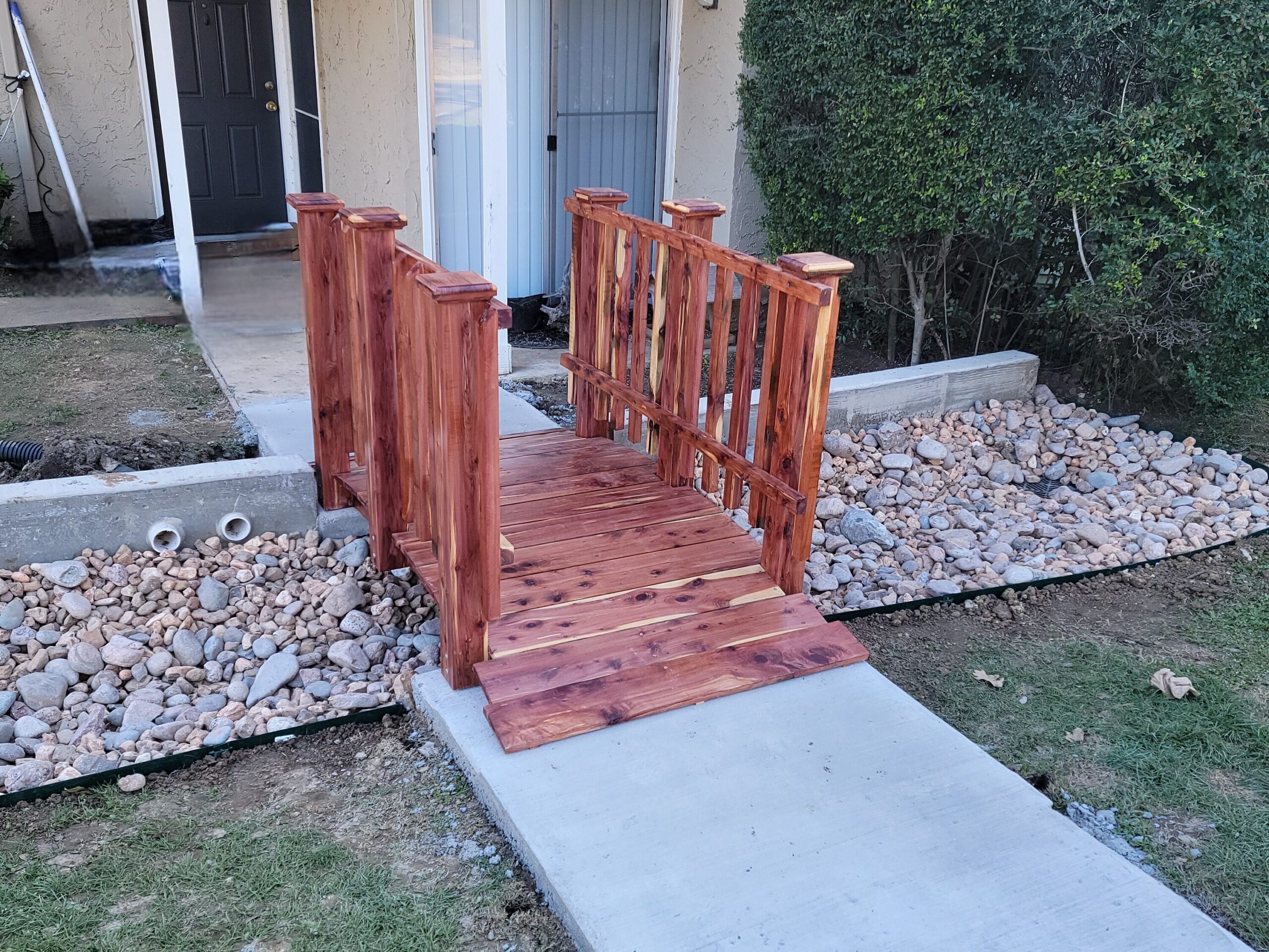 6-foot handcrafted cedar spindle rail bridge installed at Holly Springs Apartments in Denton, TX